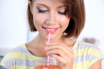 Young beautiful woman drinking fresh juice