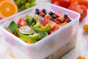 Tasty lunch in plastic containers on wooden table close up