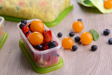 Tasty lunch in plastic containers on wooden table close up