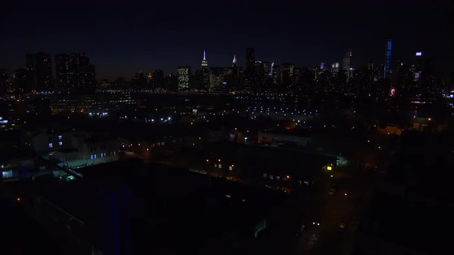 A wide angle view over Queens, New York City at dusk with the Manhattan skyline background.