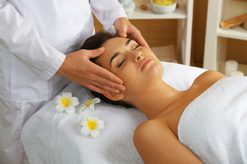 Obraz na płótnie Canvas Young woman in beauty spa salon enjoying head massage