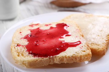 Bread with butter and homemade jam in plate, closeup