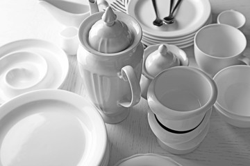 Set of white ceramics dishes on wooden table, closeup