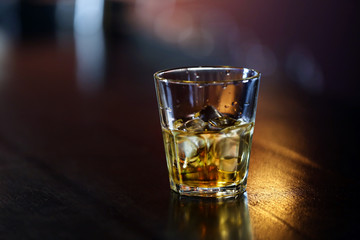 Whiskey glass tumbler standing on bar counter