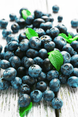 Fresh blueberries with mint on wooden table close up