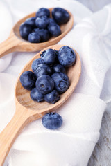 Fresh blueberries in spoons on table close up