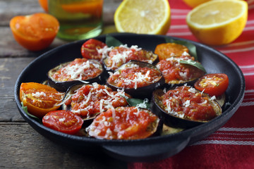Baked vegetables in pan on wooden table, close up