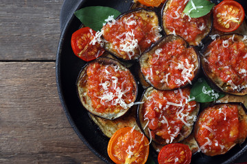 Baked vegetables in pan on wooden background