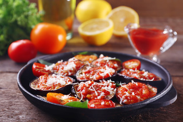 Baked vegetables in pan on wooden table