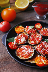 Baked vegetables in pan on wooden table