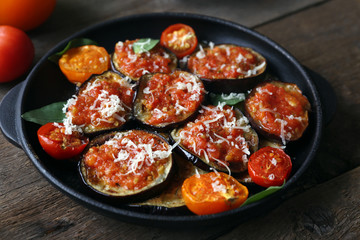 Baked vegetables in pan on wooden background