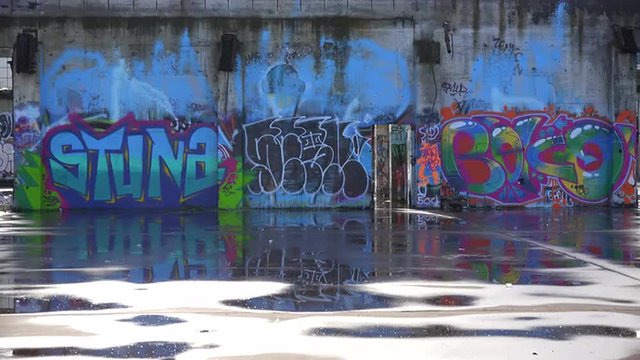 Colorful graffiti adorns an abandoned building in an urban area.