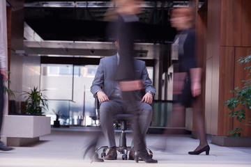 Fototapeta na wymiar business man sitting in office chair, people group passing by
