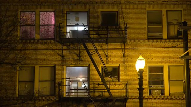 Generic establishing shot of an urban tenement or apartment complex at night.