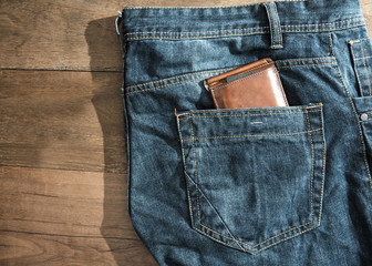 brown leather wallet in jeans back pocket blue