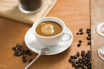 coffee cup with bean on wood table in coffee shop