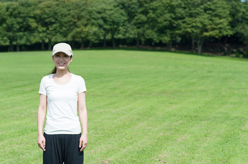 緑の芝生の上に立っている女性