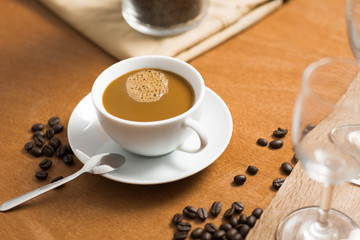 coffee cup with bean on wood table in coffee shop