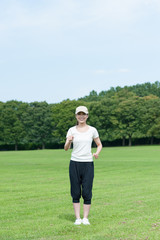 芝生の上を歩く女性