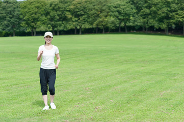 芝生の上を歩く女性