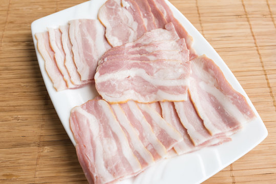 slided bacon on white dish for gourmet