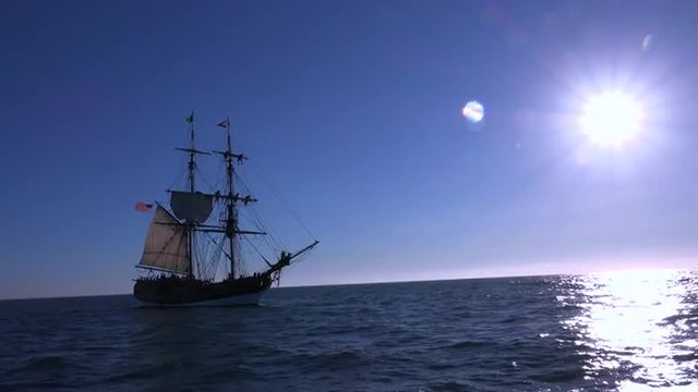 A tall masted clipper ship sails on the high seas.