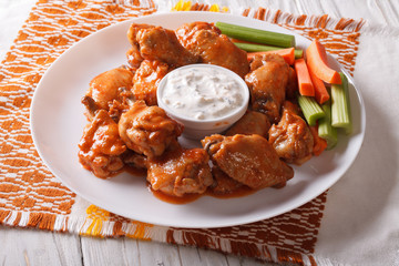 buffalo wings with cheese sauce and celery on the table 
