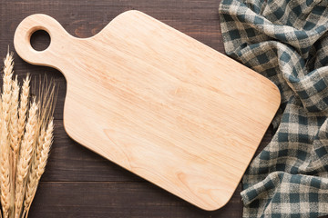 Cutting board and napkin on the wooden background. Top view