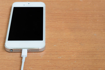 Smart phone charging on wood table