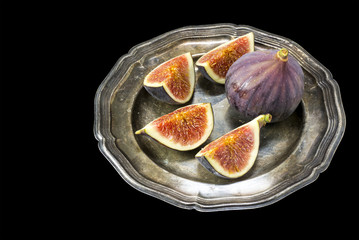 figs on a silver plate isolated on black