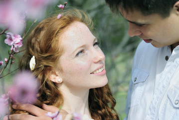 beautiful young couple in love among the flowering trees