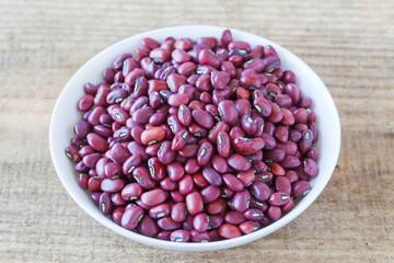 Adzuki bean or red bean in white bowl on wood background