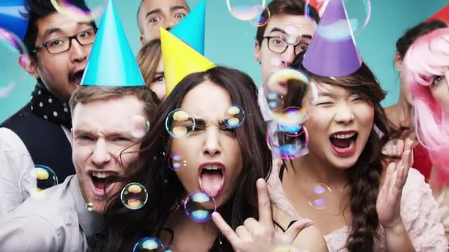 Multi racial group of happy people dancing with bubbles slow motion party photo booth 