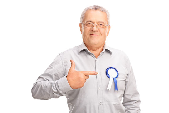 Mature man pointing to a badge on his shirt