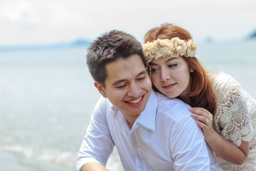 Young happy interracial couple walking on beach smiling holding