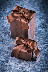 Present box wrapped in crumpled glittery paper on metallic backg