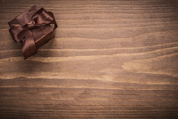 Wrapped glittery gift container on vintage wooden board copyspac