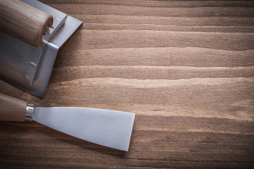paint scraper and surfacer with wooden handles on wood board
