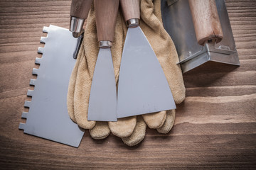 two paint scrapers putty knifes working gloves angle former