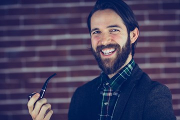 Portrait of happy man smoking pipe 