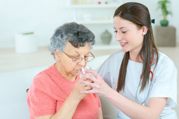 Giving senior lady a glass of water