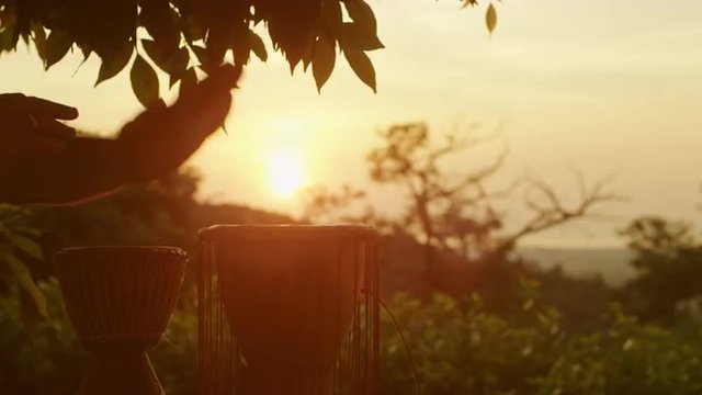 Playing Ethnic Drums Outdoors at Sunset Time