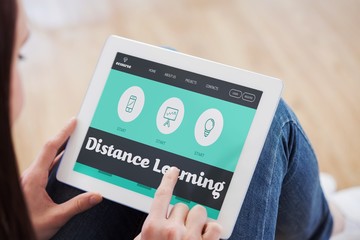 Composite image of teen using a tablet pc sitting on the floor