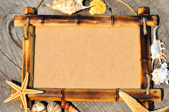 frame decorated with shells on wooden background