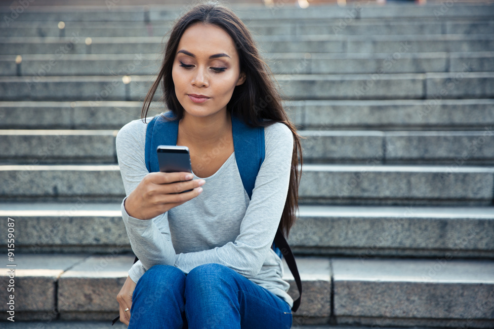 Wall mural beautiful woman using smartphone outdoors