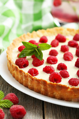 Sweet tart cake with raspberries on grey wooden background