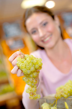 Woman holding a bunch of green grapes