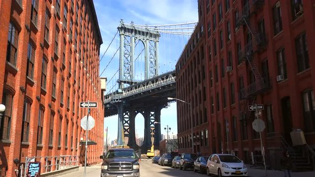An establishing shot of the Dumbo area of Brooklyn, New York, including the Manhattan bridge in distance.