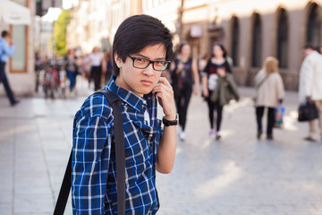 Asian man with glasses stand at street, closeup portrait.