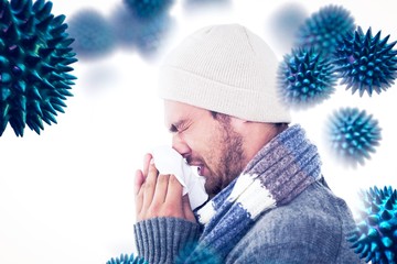 Composite image of handsome man in winter fashion blowing